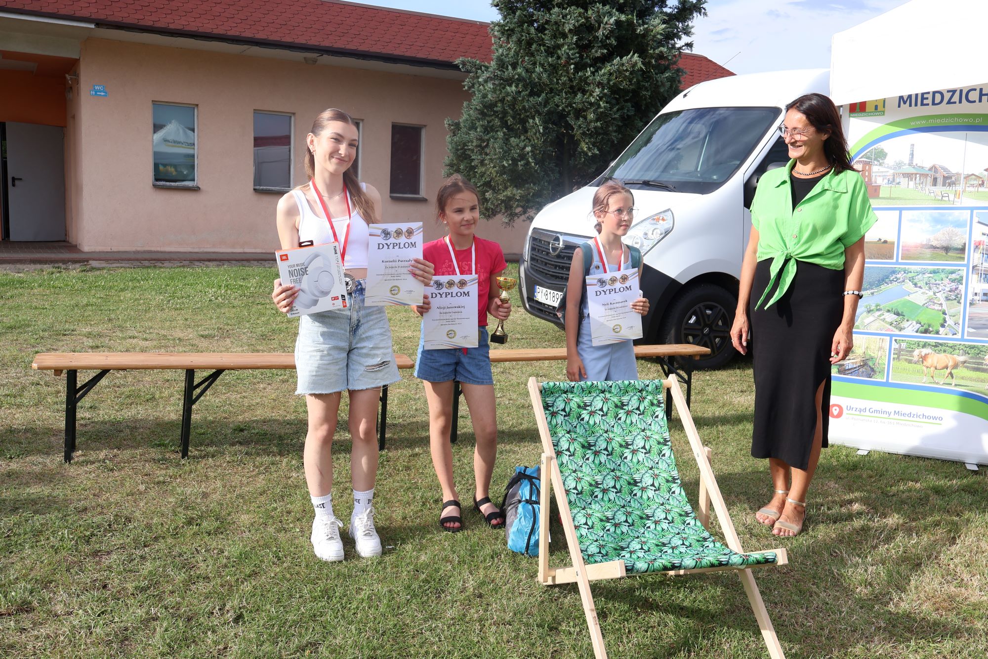 wręczenie nagród w kategori dziewczęta. Cztery panie stoją frontem do przodu na zielonej trawie. Ubrane są w jasne kolory.