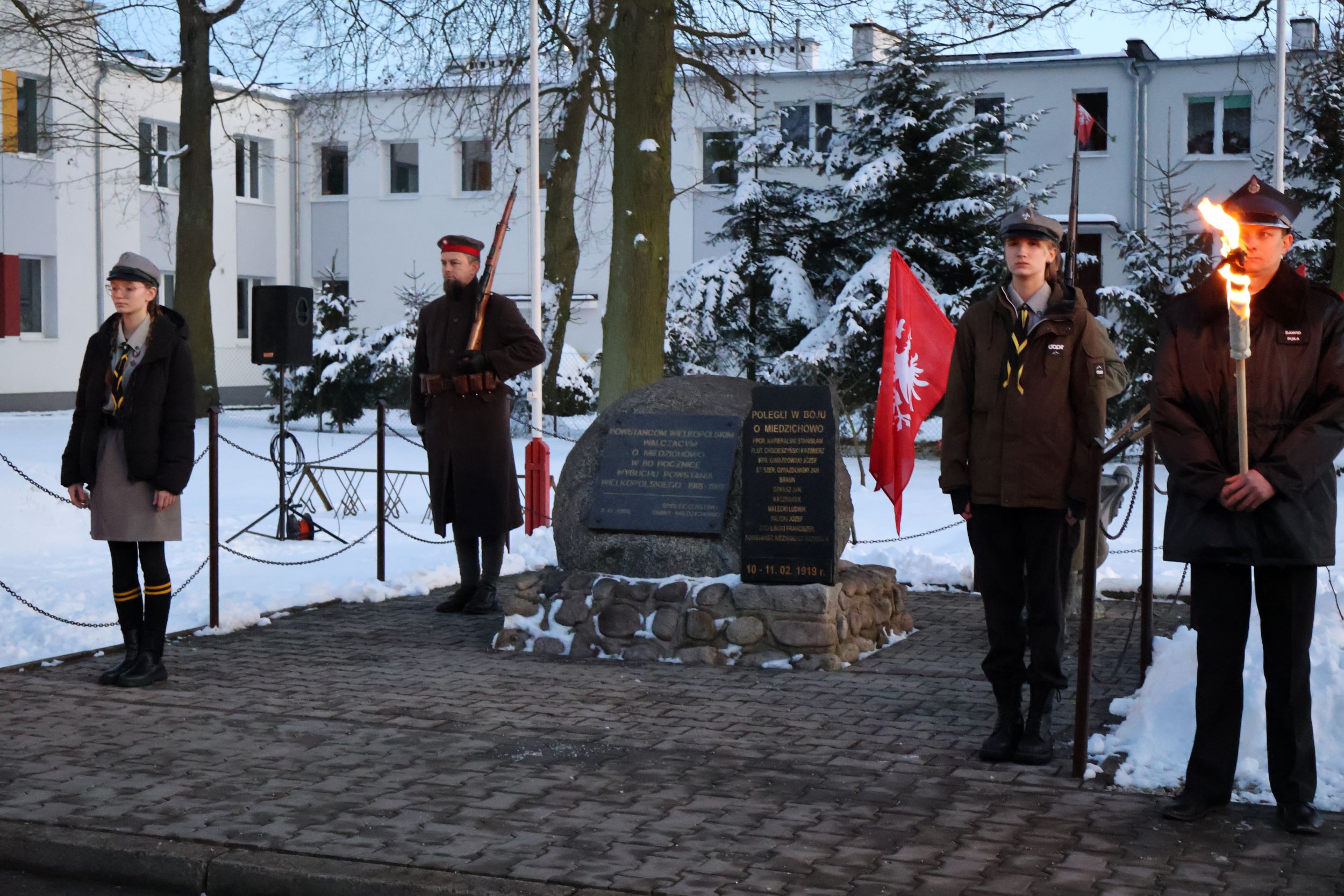 Warta honorowa przy obelisku powstańc&oacute;w wielkopolskich w&nbsp;miedzichowie. na&nbsp;pierwszym planie stoją druhowie OSP miedzichowo następnie stoją harcerze a&nbsp;p&oacute;żniej towarzystwo działań historycznych.