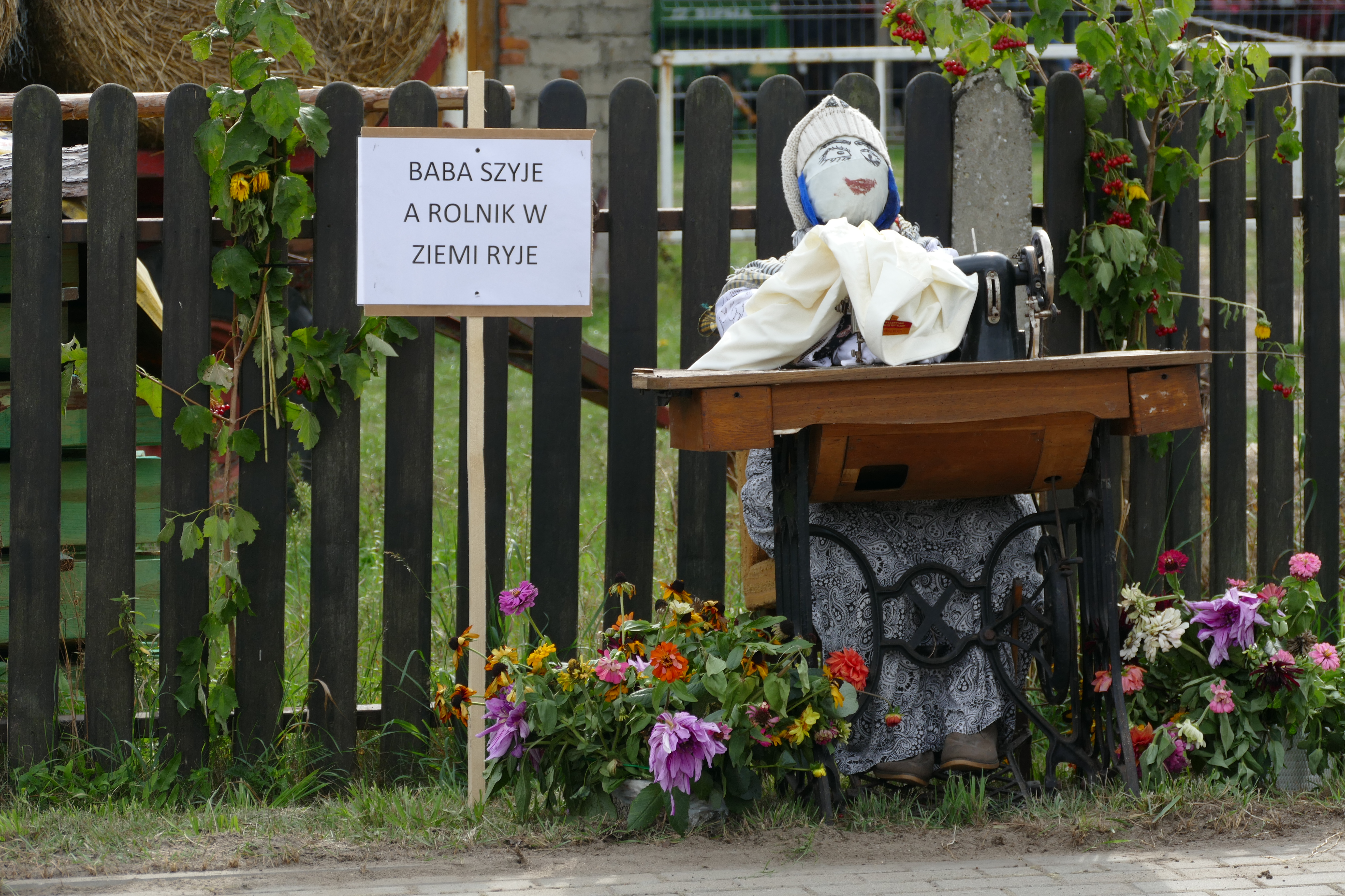 Wystrój na Dożynkach Gminnych w Grudnej - kukła wykonana z słony i przebrana w kobietę, która szyję na maszynie.