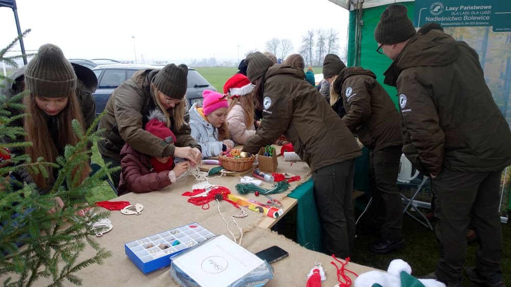 Stoisko Nadleśnictwa Bolewice, kt&oacute;re miał do zaoferowania warsztaty edukacyjne dla dzieci. Dzieci siedzą i&nbsp;wykonują r&oacute;żne karty pracy przy pomocy rodzic&oacute;w i&nbsp;pomocnik&oacute;w z&nbsp;Nadleśnictwa.